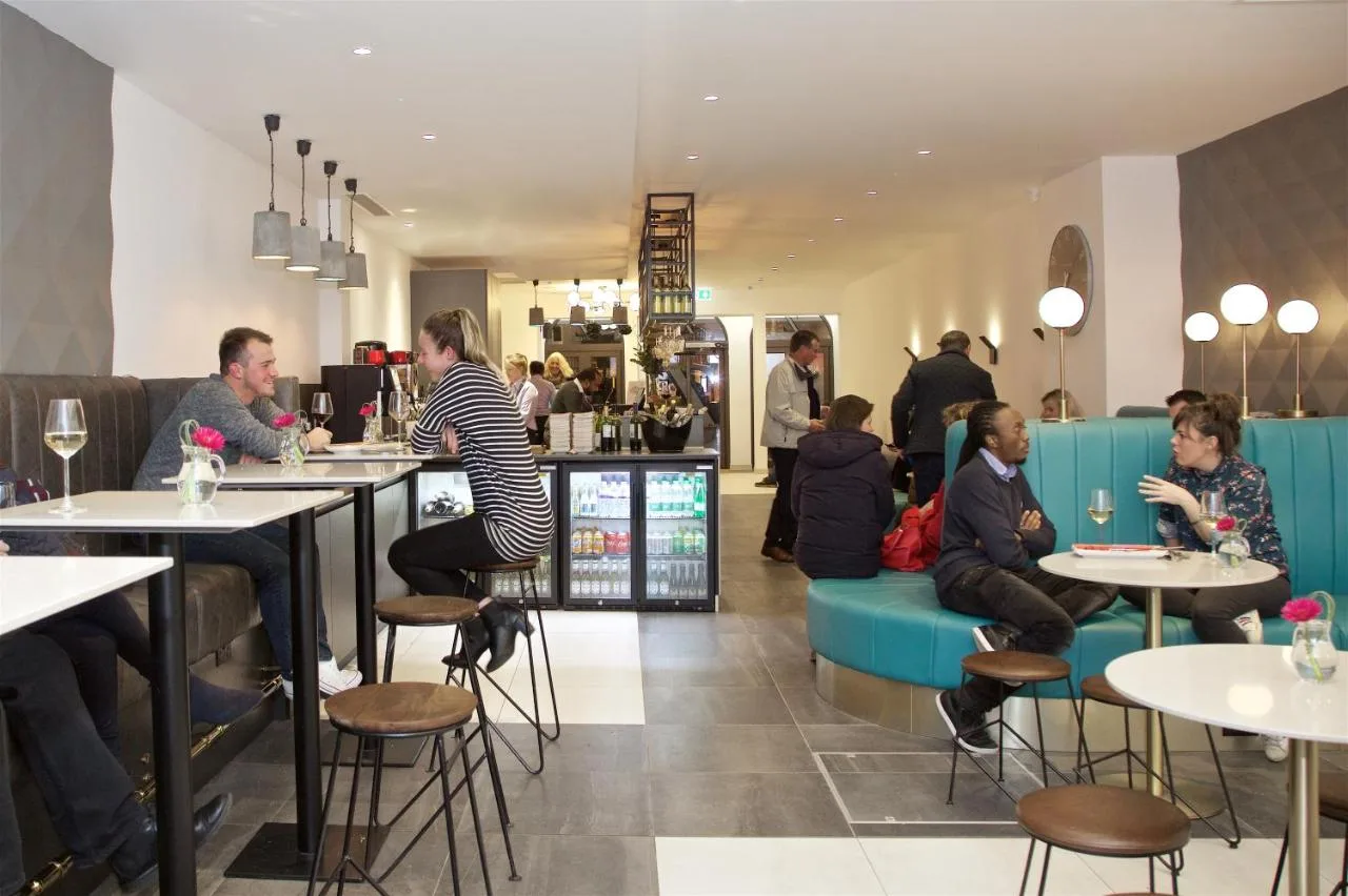 a group of people sitting at tables in a restaurant at The Z Hotel Bath in Bath