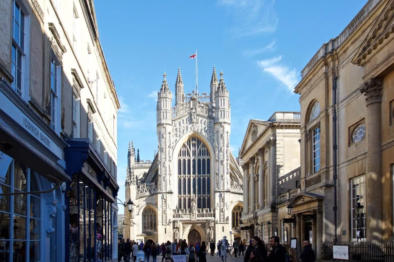 a large building with a tower on a street at The Z Hotel Bath in Bath